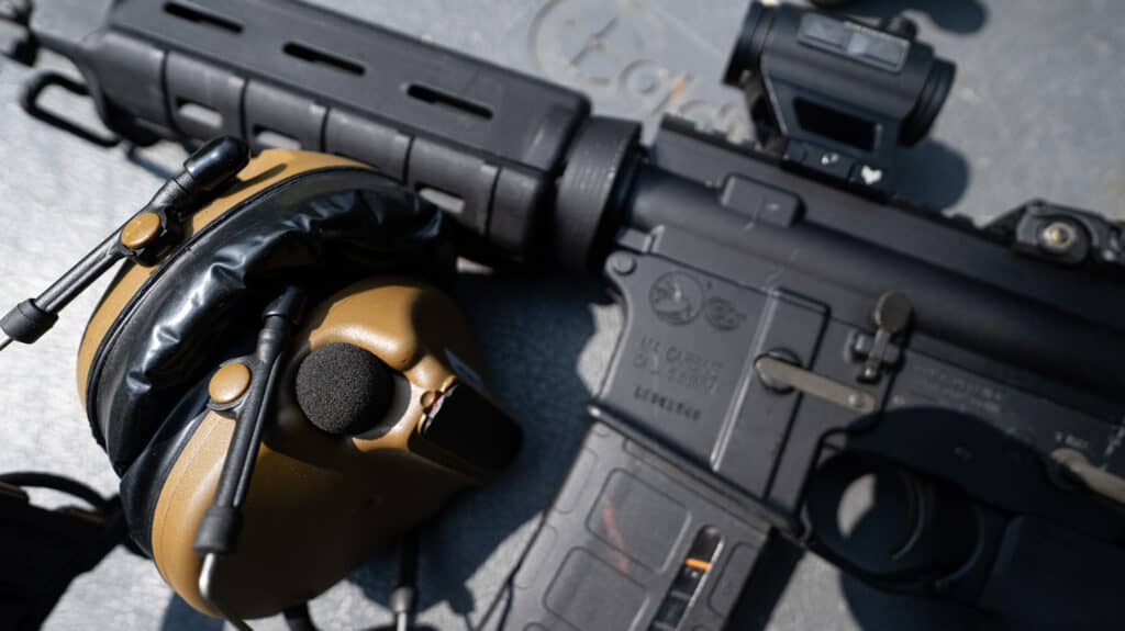 AR-15 rifle with ear protection on a shooting bench