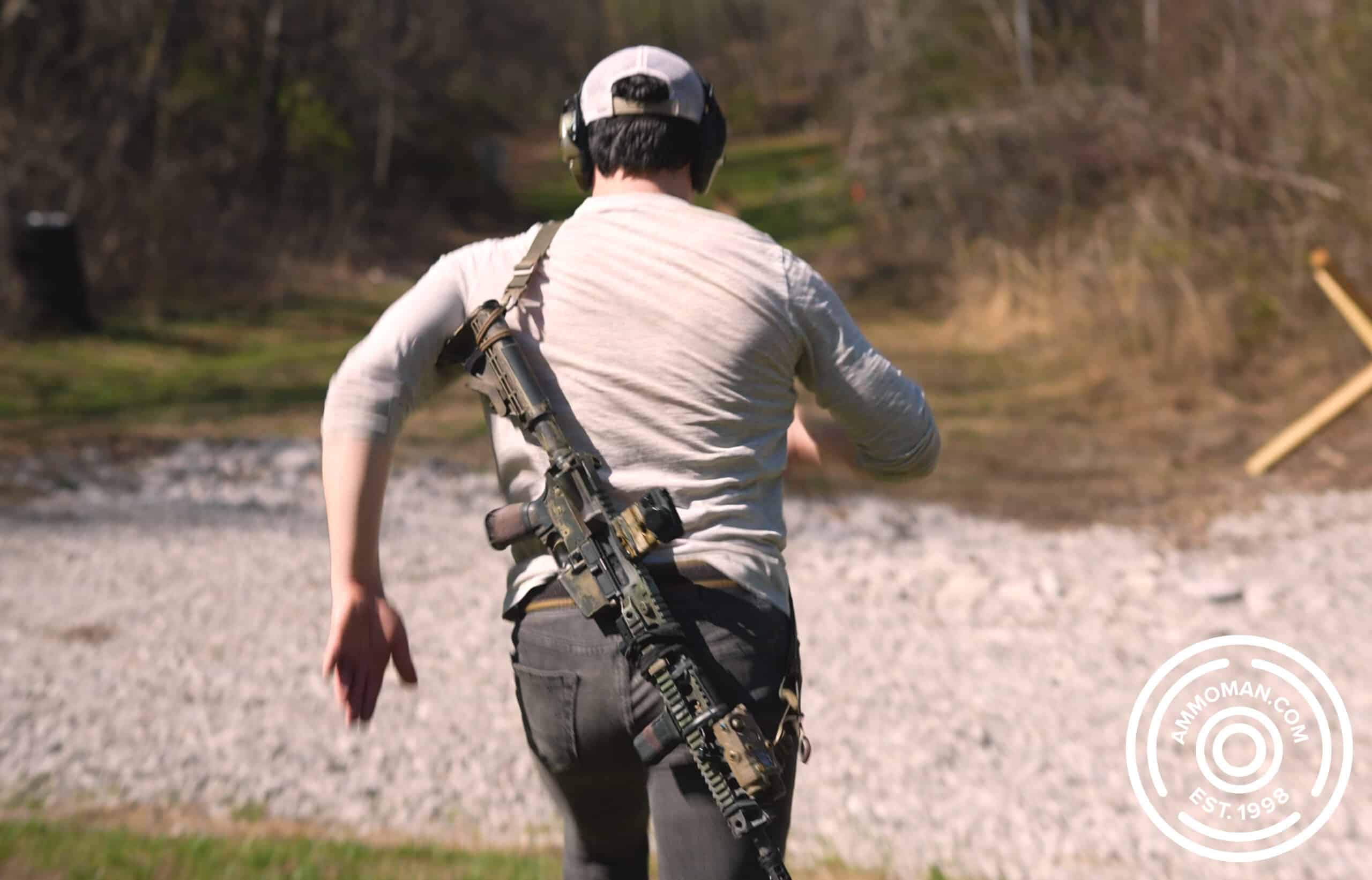 Man running with rifle slung on back