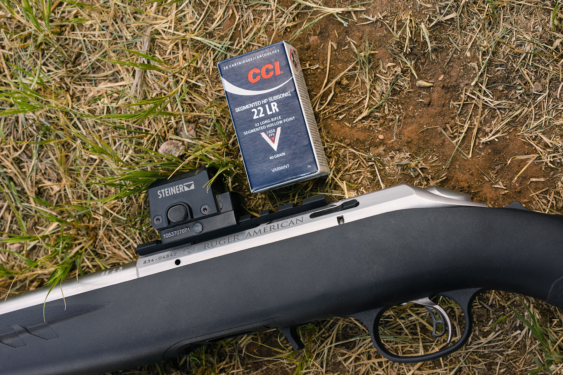 CCI Subsonic 22 long rifle ammo with a rifle on the ground at a shooting range