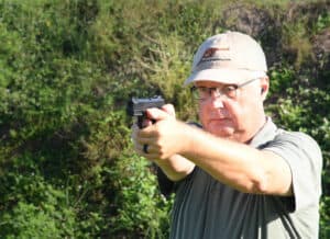 The author shooting the Ruger Security 9 at a shooting range as part of his pistol review.