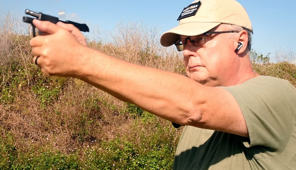 the author shooting a pistol and demonstrating recoil from a 22 