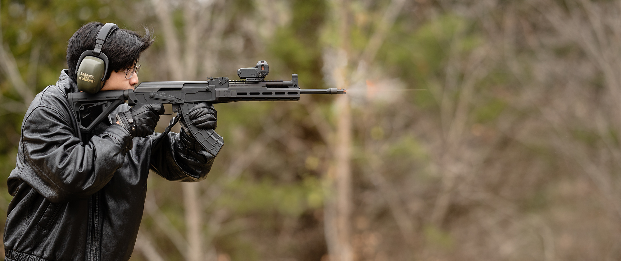 A rifleman firing an AK-47 with a meprolight at a shooting range
